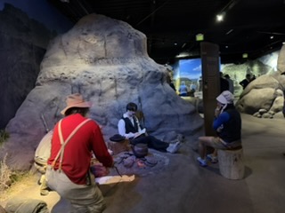 Group member in pioneer bonnet with the Gold Rush exhibit