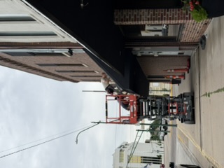 Roofers working on an angled metal roof in downtown York